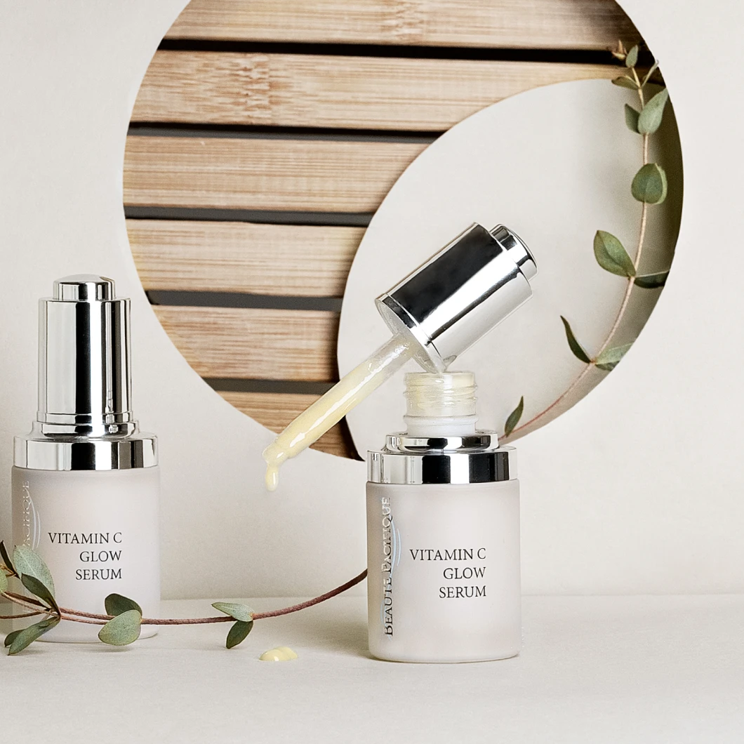 Beauté Pacifique Vitamin C Glow Serum i frostet glassflaske med sølvfarget pipette og pumpe mot en dekorativ bakgrunn. På emballasjen vises tekstene "VITAMIN C GLOW SERUM" og "BEAUTÉ PACIFIQUE".