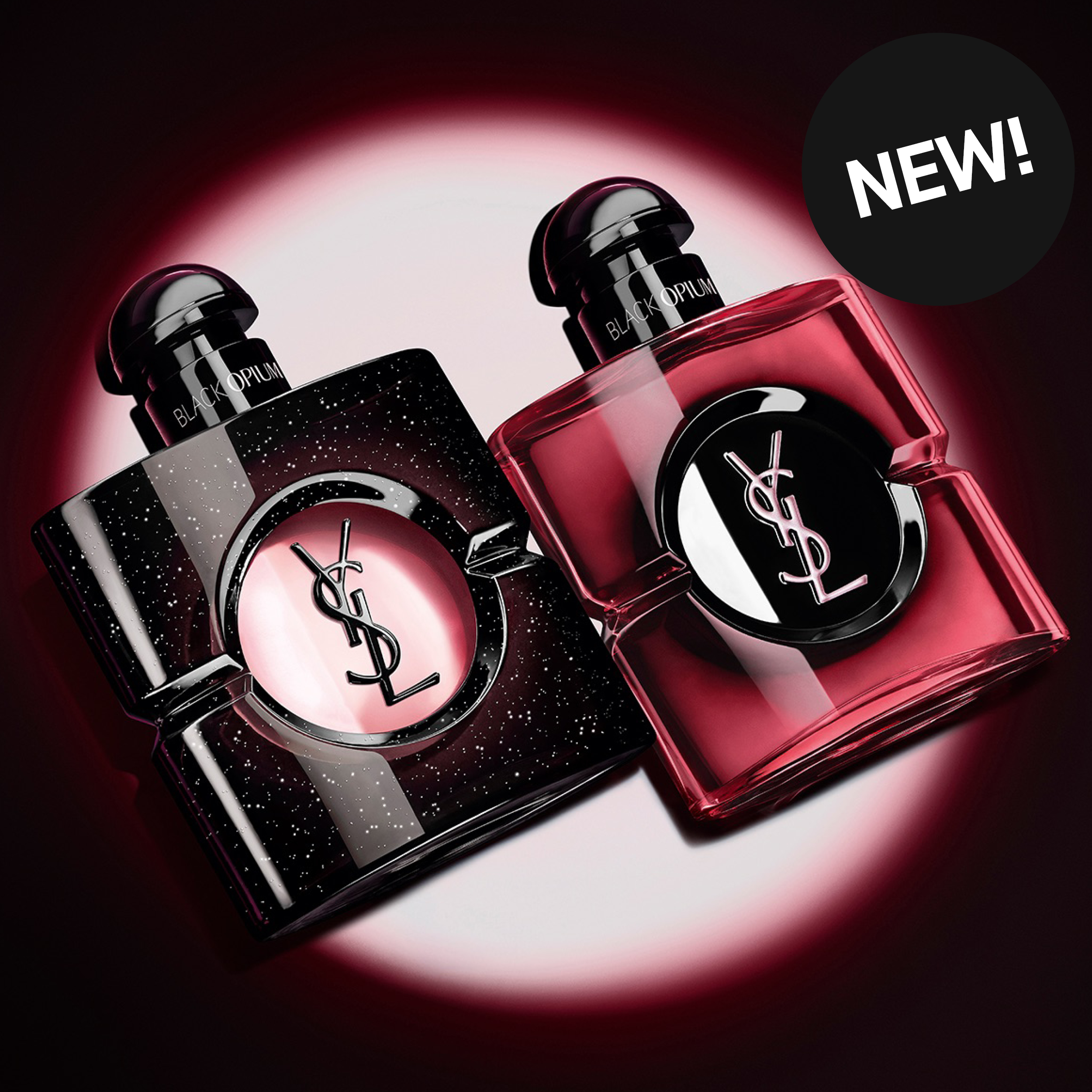 Två Yves Saint Laurent Black Opium-parfymer visas mot en mörk bakgrund med rosa ljuseffekt. Flaskorna har texten "BLACK OPIUM" och YSL-logotypen, och en svart cirkel med texten "NEW!" syns i det övre högra hörnet.
