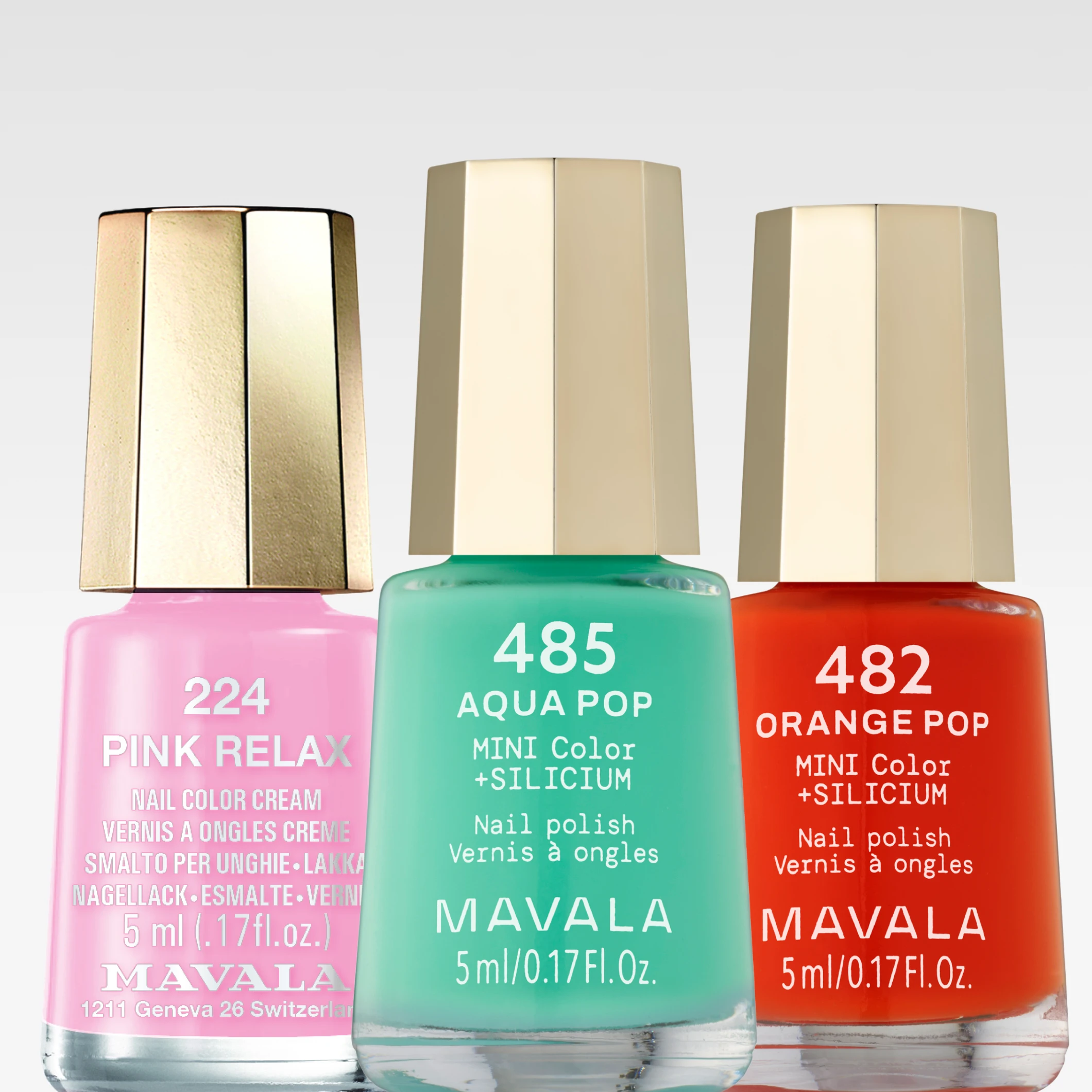 Närbild på Mavala nagellack i färgerna Pink Relax, Aqua Pop och Orange Pop mot ljus bakgrund. Förpackningarna visar produktnamn, “MINI Color +SILICIUM” och “Nail polish”.