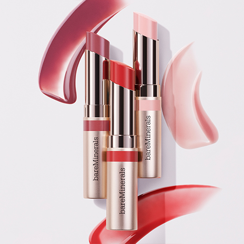 bareMinerals läpprodukter i rosa och röda nyanser, presenterade i eleganta metalliska hylsor.