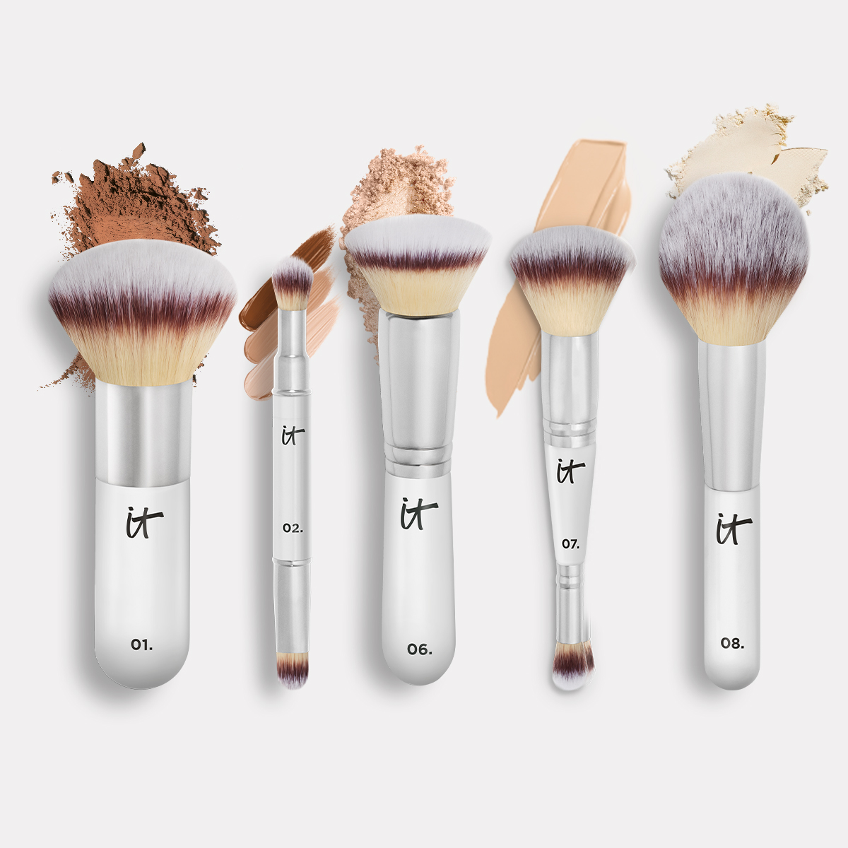 IT Cosmetics -meikkisiveltimiä vaalealla taustalla eri meikkituotteiden tekstuurien kanssa.