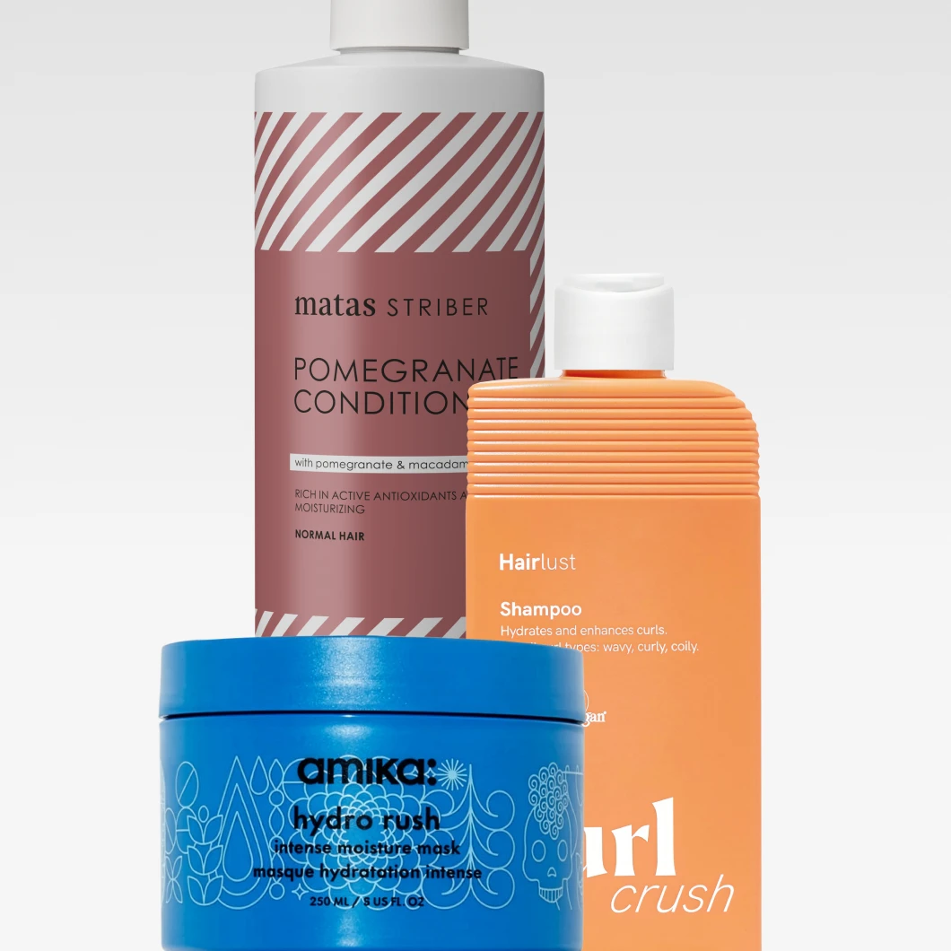 Hiustenhoitotuotteita vaaleaa taustaa vasten: Matas Striber Pomegranate Conditioner, Hairlust Curl Crush Shampoo ja Amika Hydro Rush Intense Moisture Mask. Pakkauksissa näkyvät muun muassa tekstit "matas STRIBER POMEGRANATE CONDITIONER", "Hairlust Shampoo", "curl crush" ja "amika: hydro rush intense moisture mask".