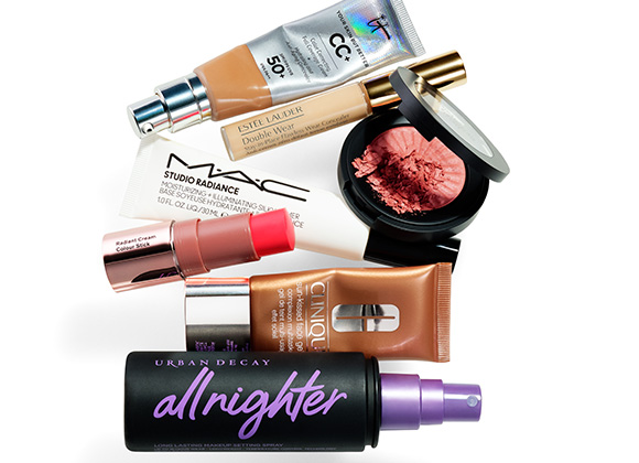 En samling av olika sminkprodukter inklusive foundation, concealer, rouge, ansiktsgel, färgstick och setting spray. Produkterna är från märken som MAC, Estee Lauder, Clinique och Urban Decay.