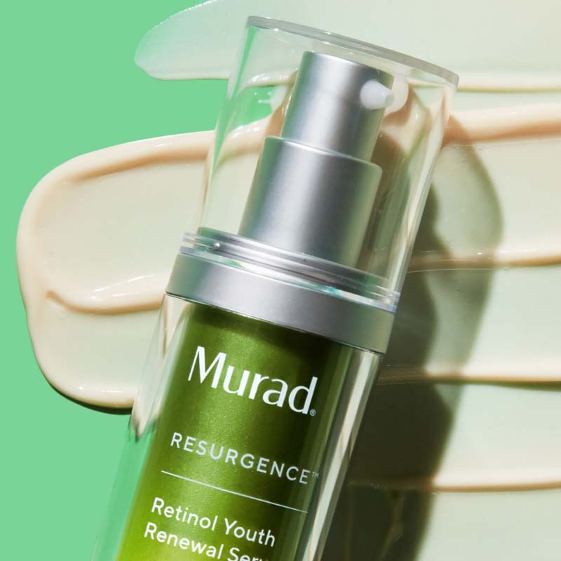 Serum från Muradplacerad mot en grön bakgrund. Flaskan är grön med en silverfärgad pump och genomskinligt lock. Bakom flaskan syns en applicerad mängd av serumet, vilket framhäver dess krämiga konsistens och hudvårdande egenskaper.