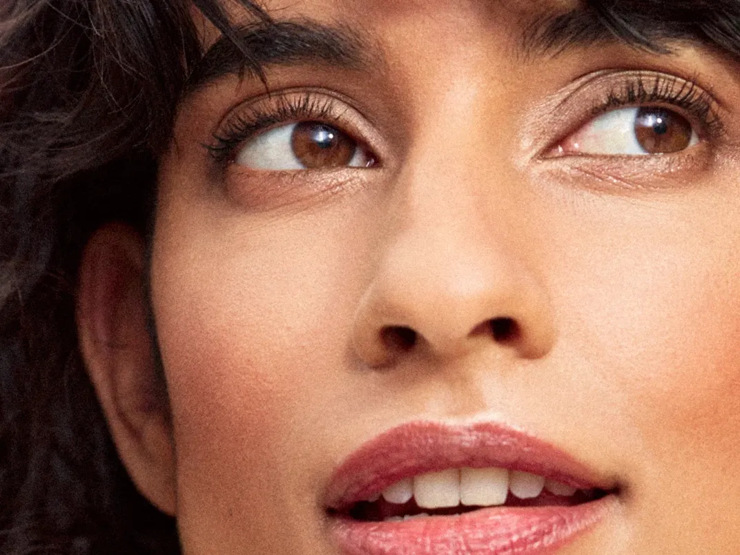 Kvinna med bruna ögon, mörkt hår och naturligt bronserad makeup.