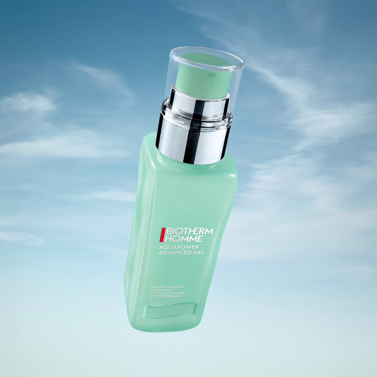 Biotherms Homme Aquapower Advanced Gel. Gelén kommer i en grön pumpflaska med silverdetaljer och har texten "Biotherm Homme Aquapower Advanced Gel" på framsidan. Bakgrunden är en blå himmel med några vita moln.