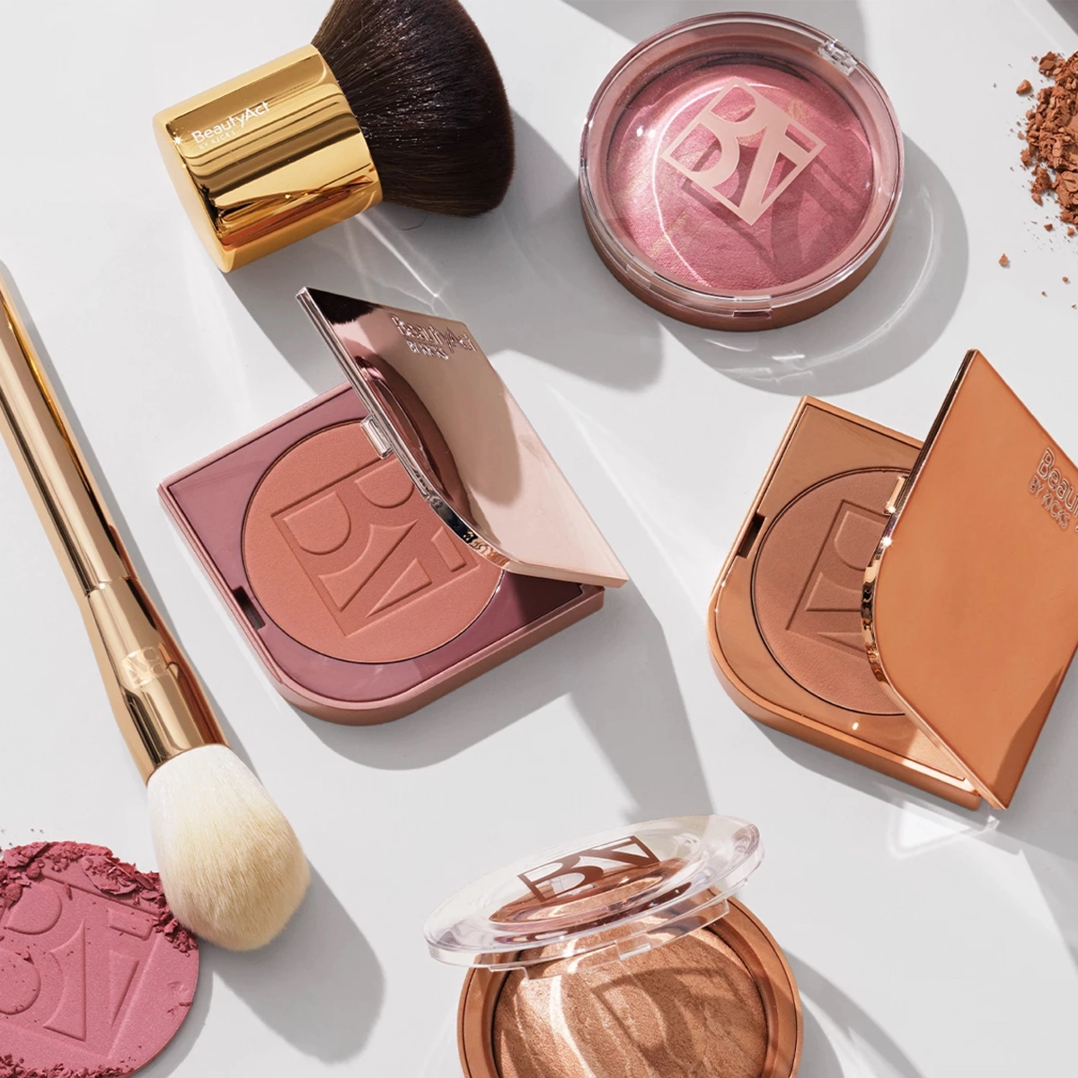Et antall makeup-produkter fra BeautyAct i solen på en hvit overflate.