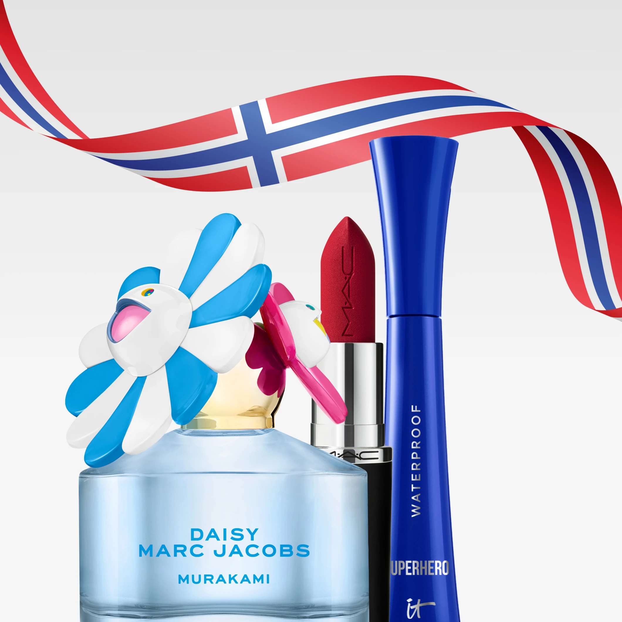 Marc Jacobs Daisy Murakami parfymeflaske med blomsterkork sammen med MAC rød leppestift og IT Cosmetics Superhero Waterproof mascara, dekorert med norsk flaggbånd.
