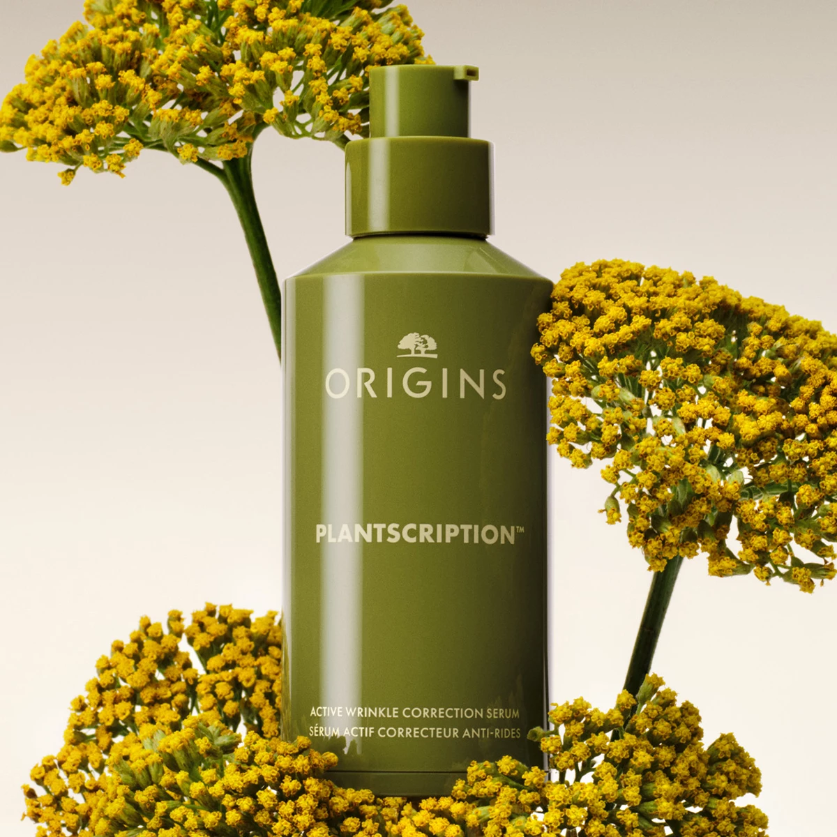 Origins Plantscription Active Wrinkle Correction Serum omgitt av gule blomster mot en lys bakgrunn.