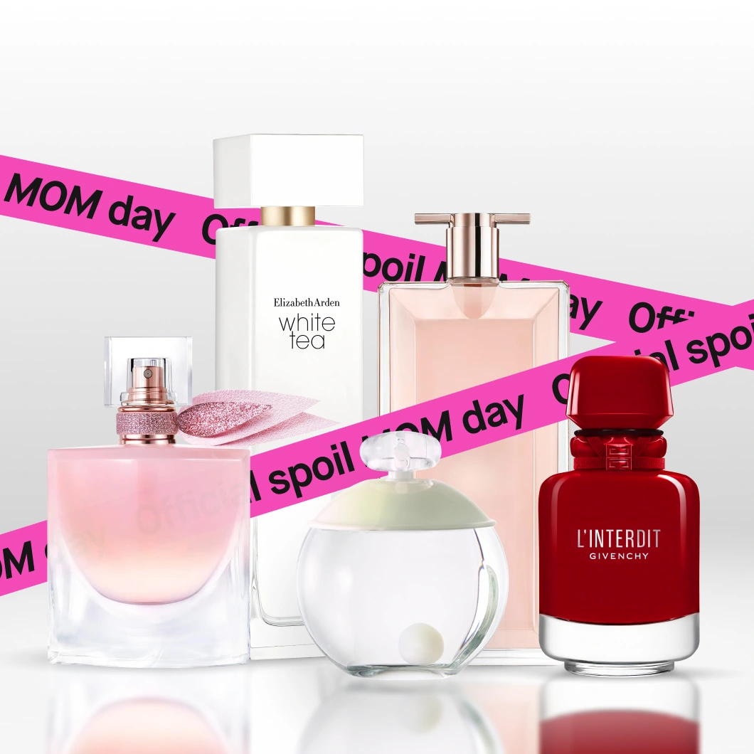 Flera parfymflaskor på ljus bakgrund, inklusive Lancôme La Vie Est Belle, Elizabeth Arden White Tea och Givenchy L’Interdit, med rosa band över bilden med texten "Official spoil MOM day".
