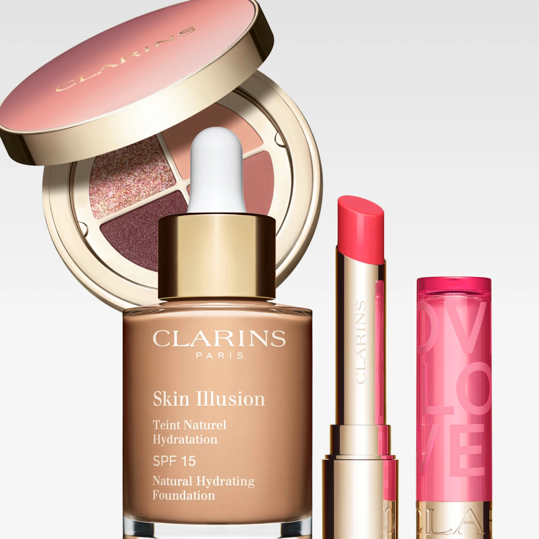 Clarins-meikkituotteita: meikkivoidepullo “Skin Illusion Teint Naturel Hydratation SPF 15 Natural Hydrating Foundation”, huulipuna tekstillä “CLARINS” sekä luomiväripaletti, jonka kannessa lukee “CLARINS”.