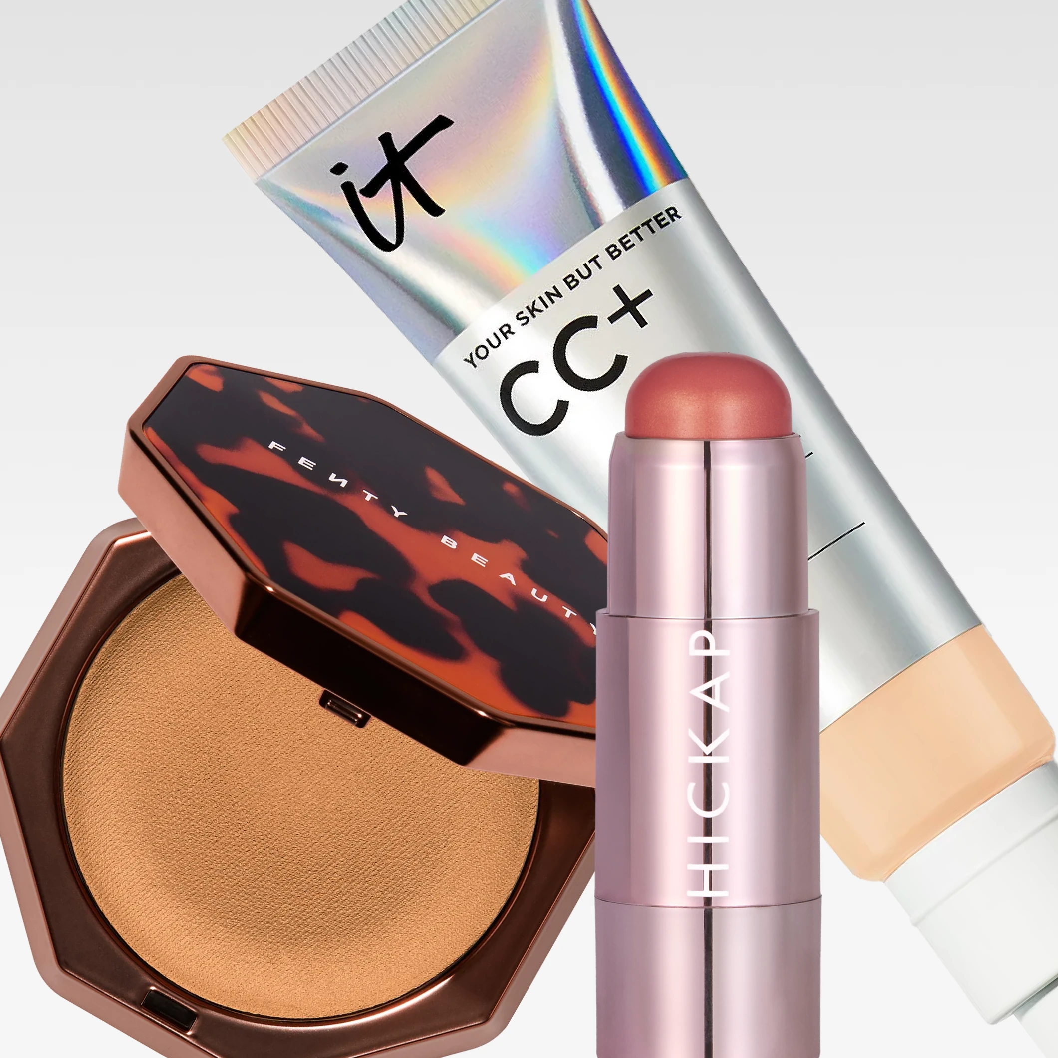 Kolme meikkituotetta vaaleanharmaata taustaa vasten: IT Cosmetics CC+ Color-Correcting Full-Coverage Cream SPF 50+, avoin Fenty Beauty -puuteri sekä HICKAP-meikkipuikko. Näkyvä teksti sisältää ”it”, ”YOUR SKIN BUT BETTER”, ”CC+”, ”COLOR-CORRECTING”, ”Full-Coverage”, ”Hydrating Serum”, ”SPF/FPS UVB 50+”, ”FENTY BEAUTY” ja ”HICKAP”.