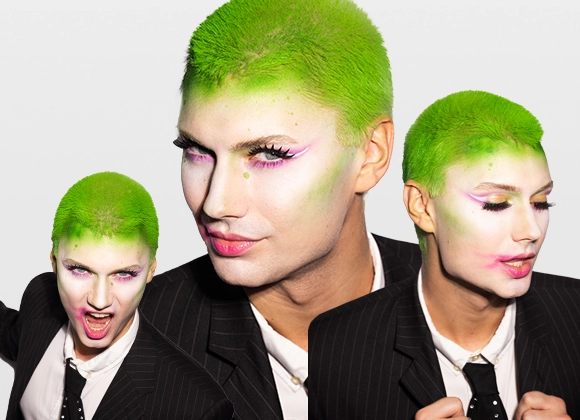 Bild som visar tre bilder på samma person med grönt hår och klädd i en svart kostym med vit skjorta och svart slips, från olika vinklar. Personen står mot en vit bakgrund.