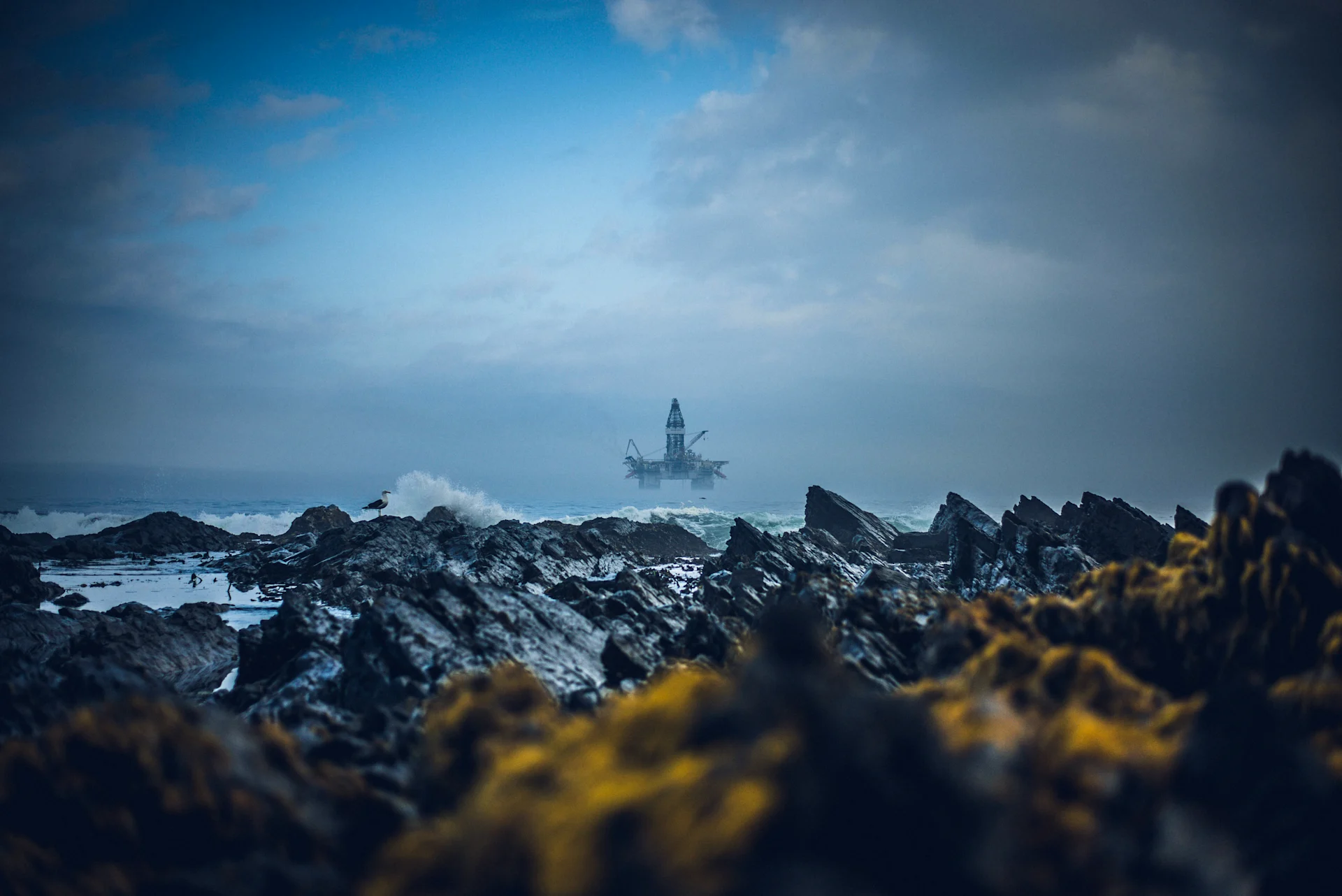 Oil rig through the gray rocks