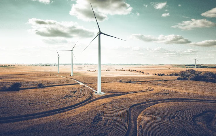 An expansive onshore wind farm with towering turbines set against open fields, showcasing the power of renewable energy and sustainable innovation in clean energy production.
