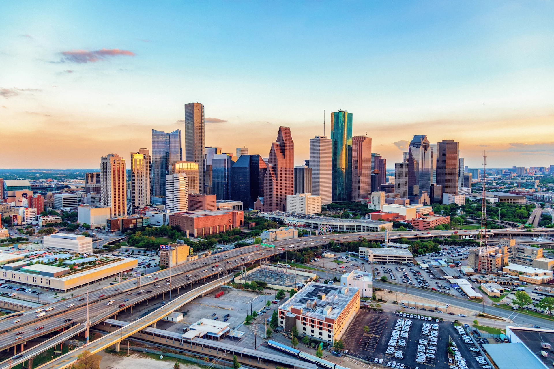 A stunning view of downtown Houston at sunset, showcasing the city’s iconic skyline with its mix of modern skyscrapers and vibrant urban landscape.