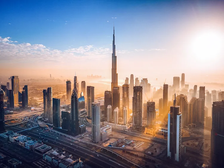 A breathtaking sunrise over Dubai's iconic skyline, featuring the towering Burj Khalifa amidst a sea of modern skyscrapers, showcasing the city’s architectural grandeur.
