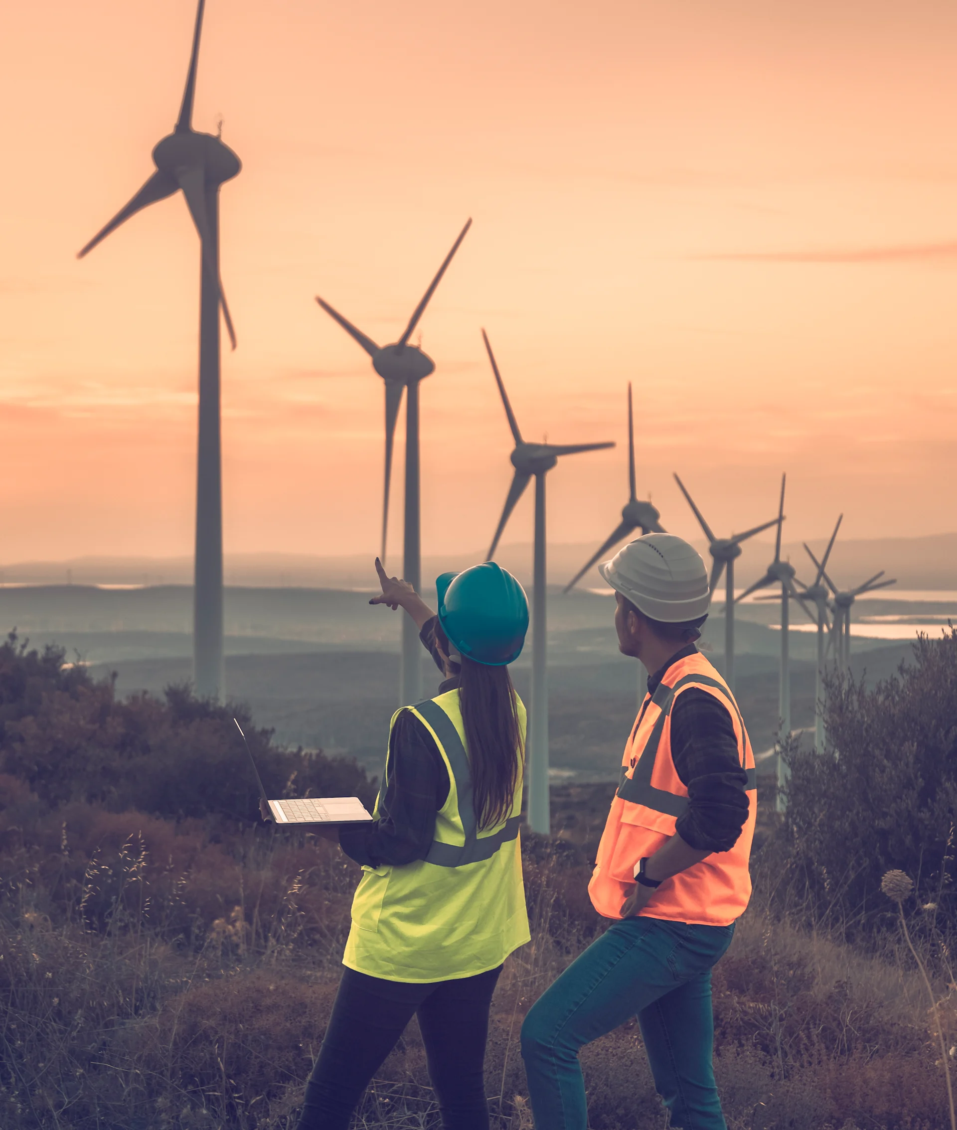 woman and man standing in front of wind turbines