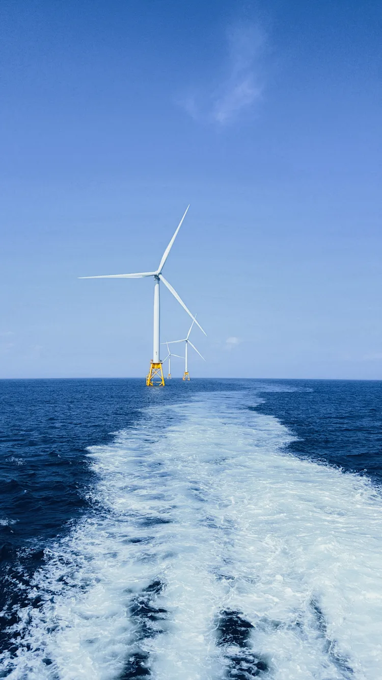 Three white wind turbine on sea