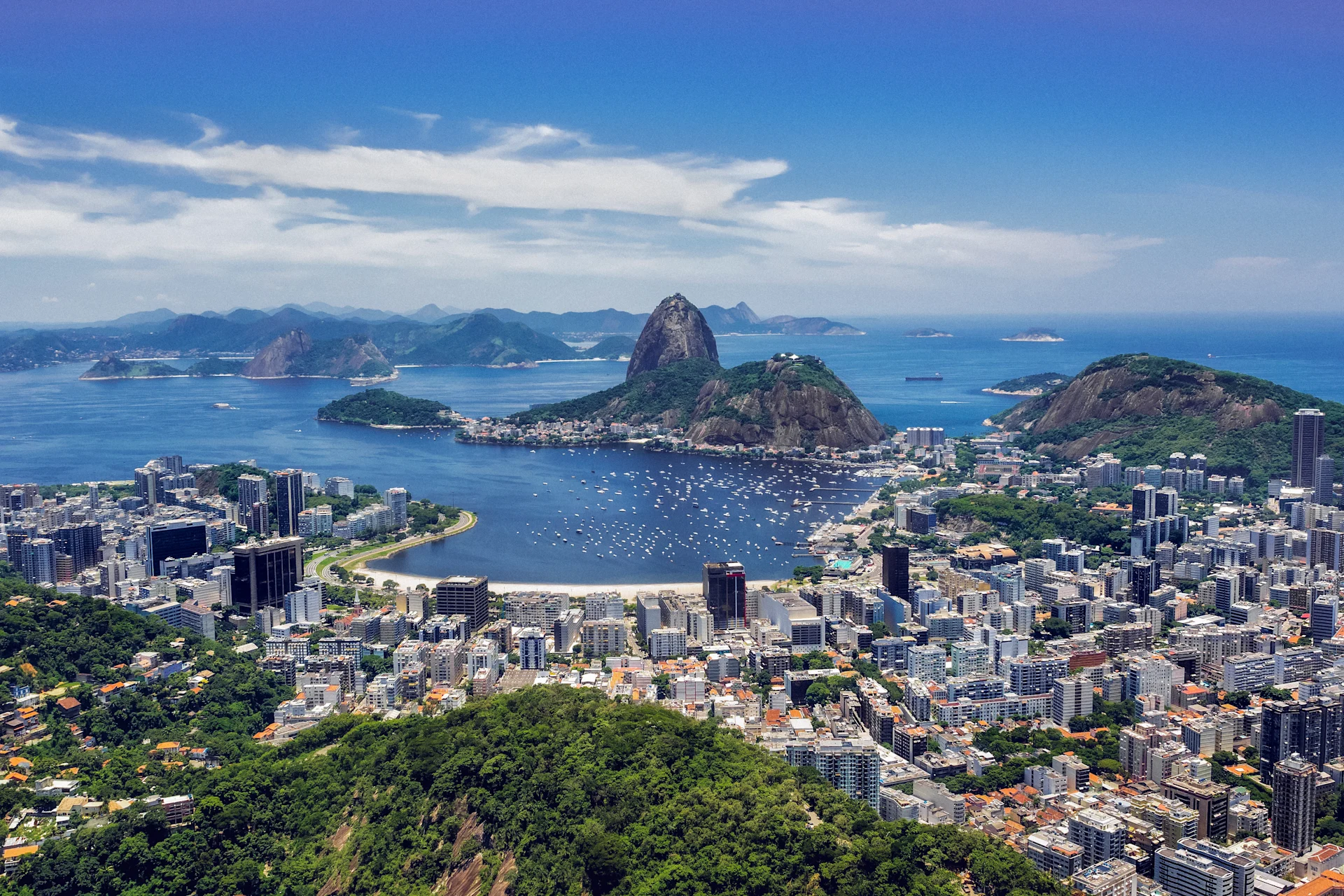 view of Rio de Janeiro featuring Sugarloaf Mountain, surrounded by lush landscapes, vibrant cityscape, and the stunning Guanabara Bay waters.