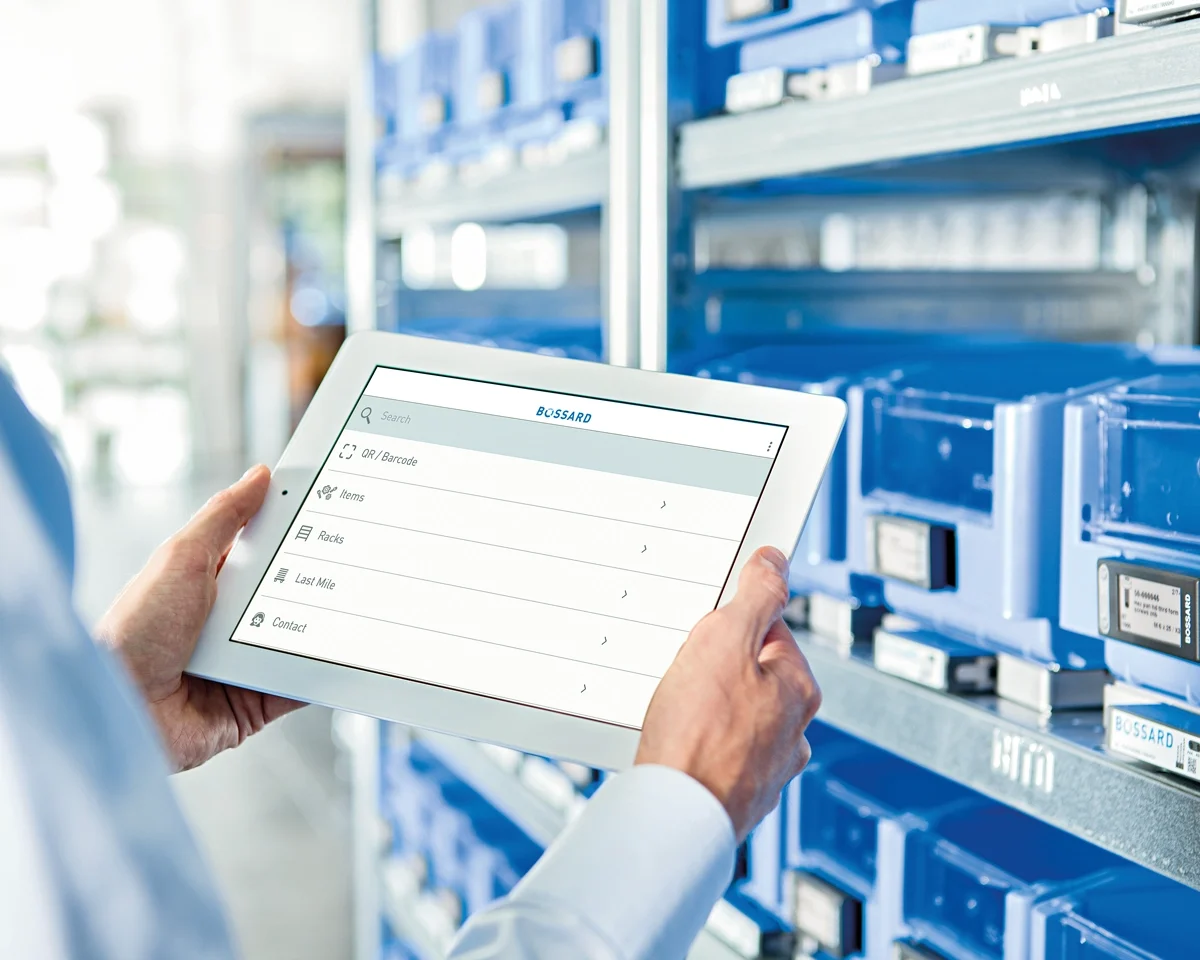 
Người đang kiểm tra thông tin cổ phiếu trên máy tính bảng trước các thùng chứa C-part