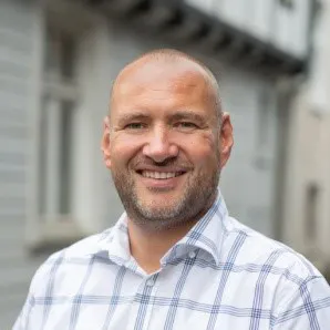 Porträt von Sascha Ahmetovic, lächelnd im Freien