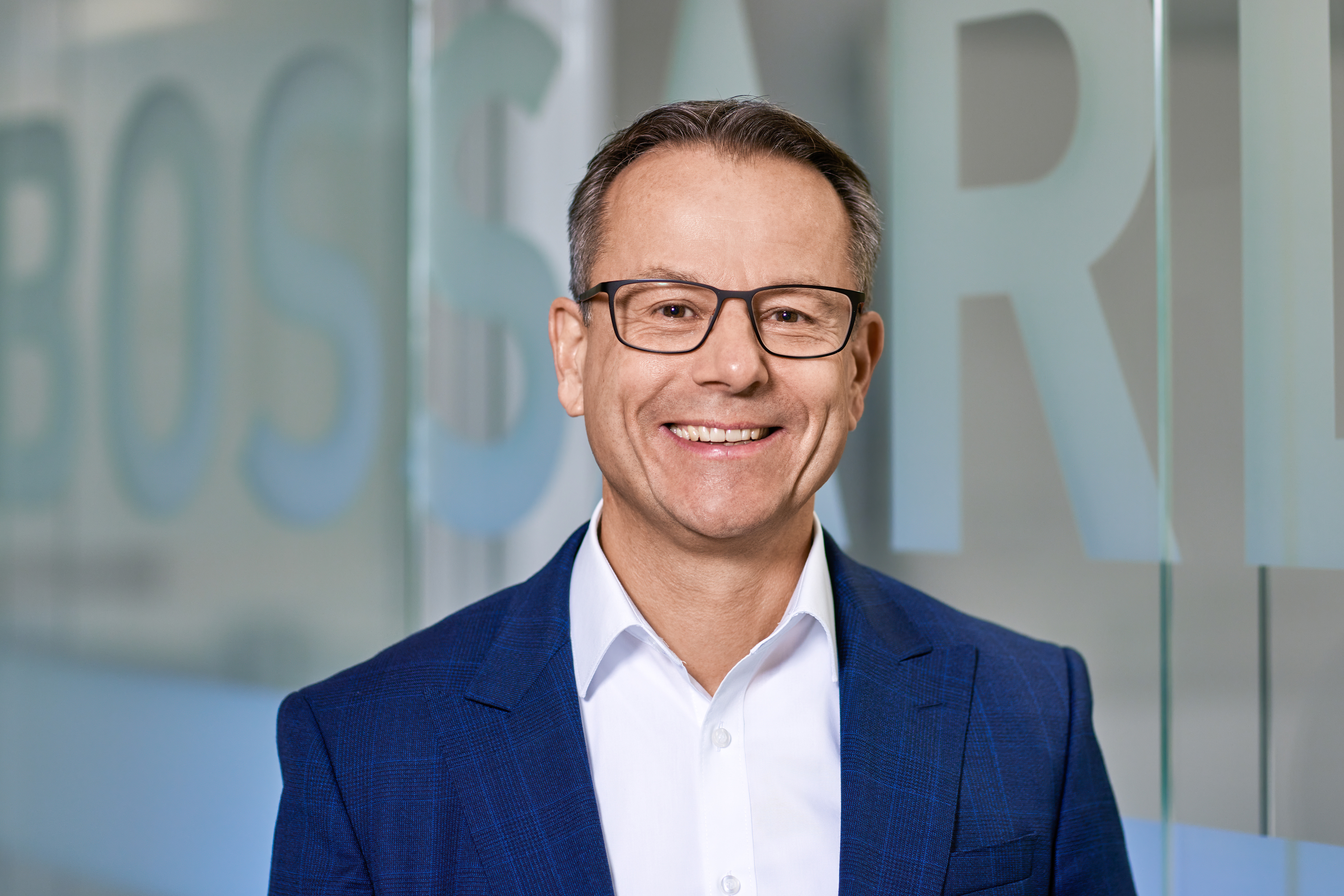 Fotó Stephan Zehnderről a Bossard logóval a háttérben.