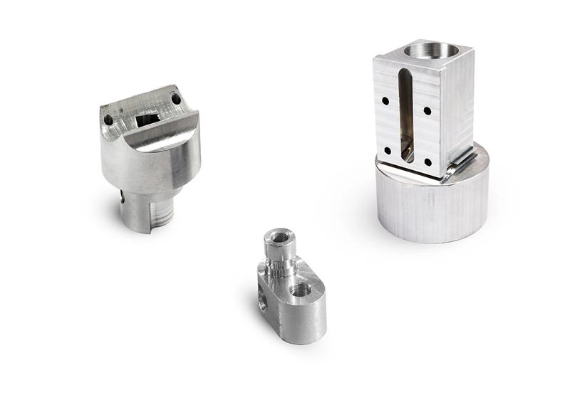 3 fræsede metalemner på hvid baggrund