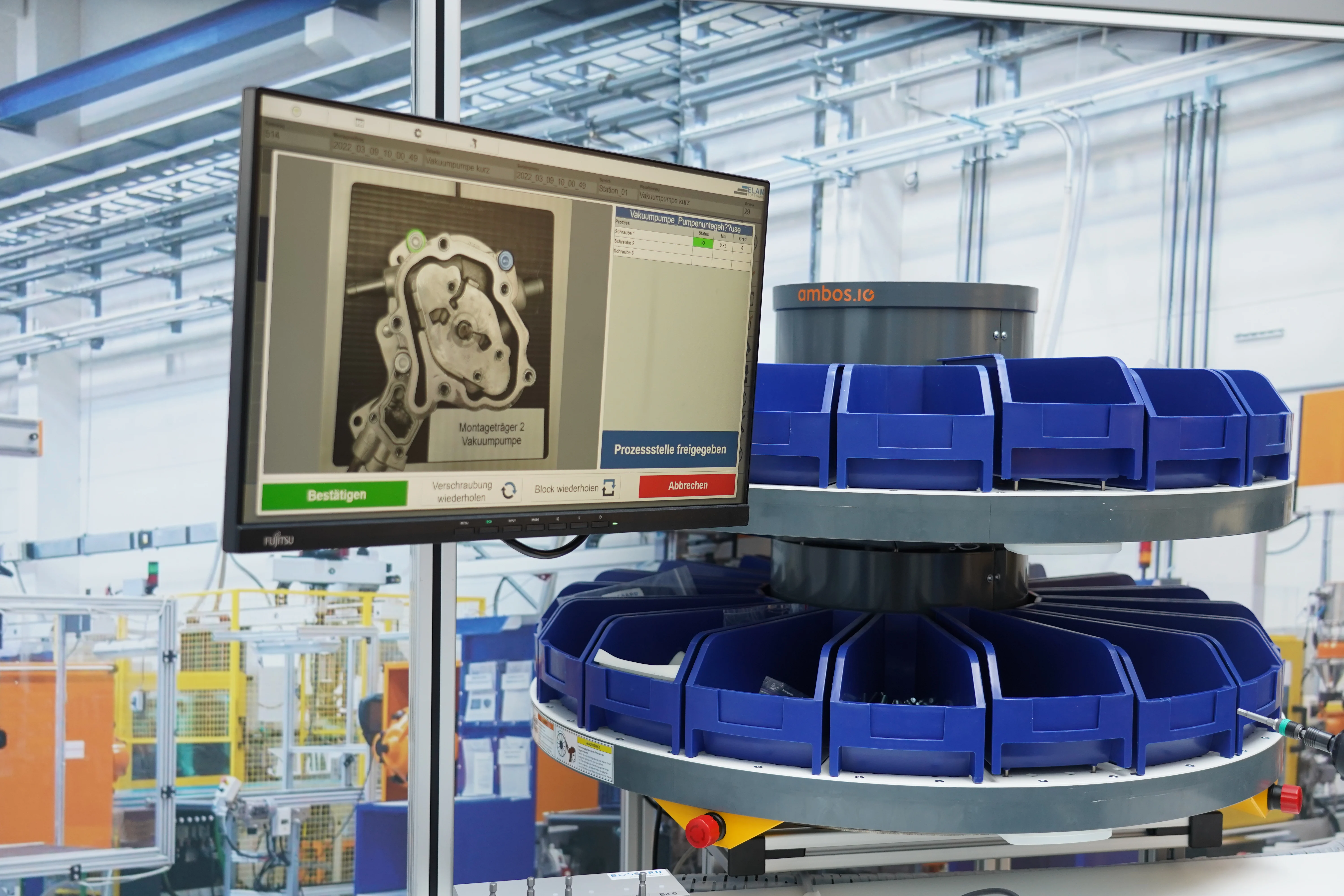 Fast display med digitale arbejdsinstruktioner og ELAM-løsninger samt et smartbin-tårn ved siden af.