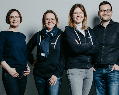 Vier Teammitglieder von Bossard Deutschland aus dem Bereich People & Organizational Development vor grauem Hintergrund.