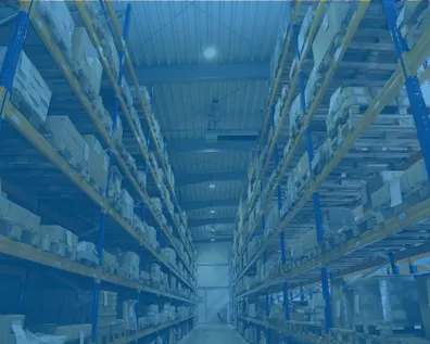 Lagerhalle mit hohen Regalen, gefüllt mit Kartons und Paletten