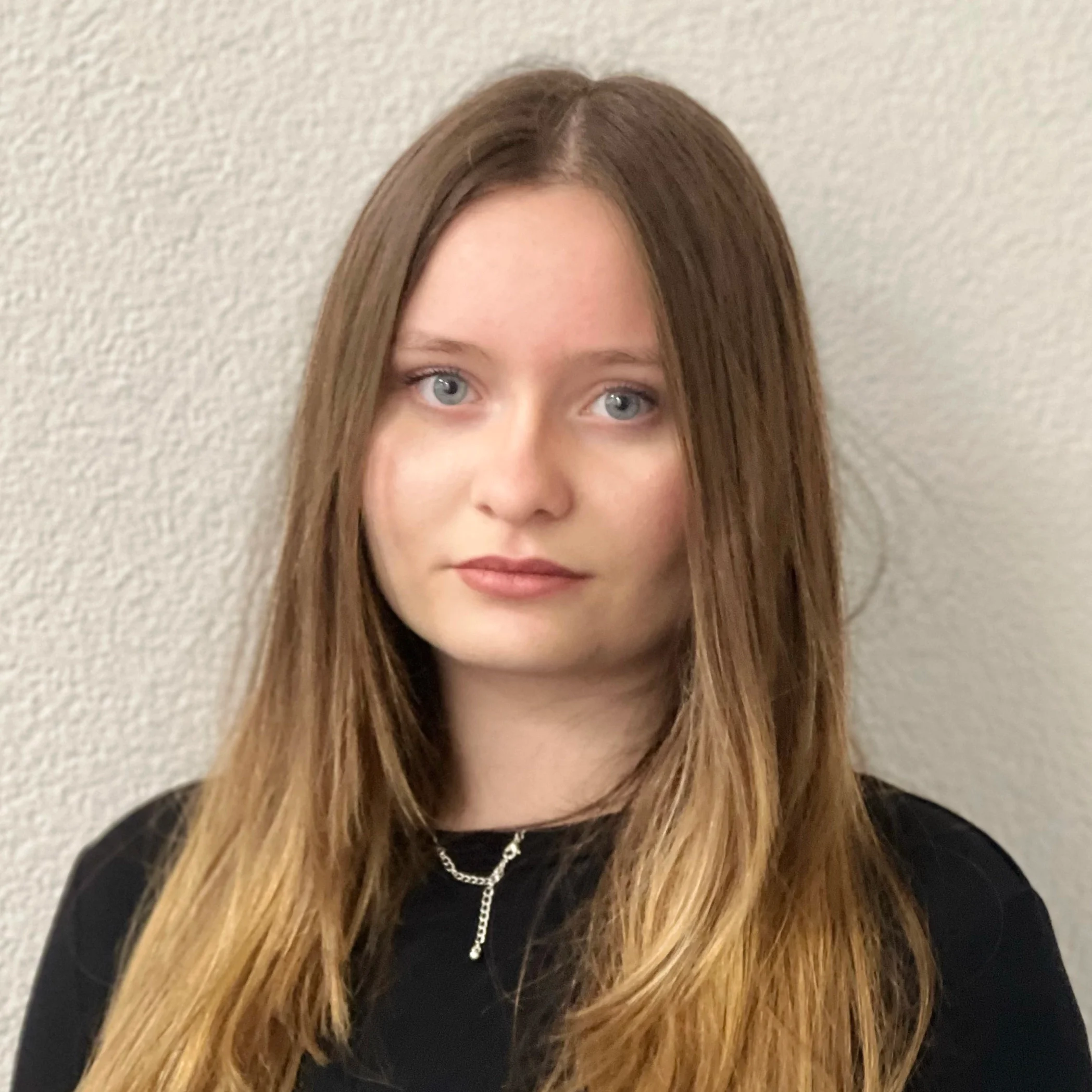 Portrait Aufnahme einer jungen Frau mit braunen Haaren und blaugrünen Augen