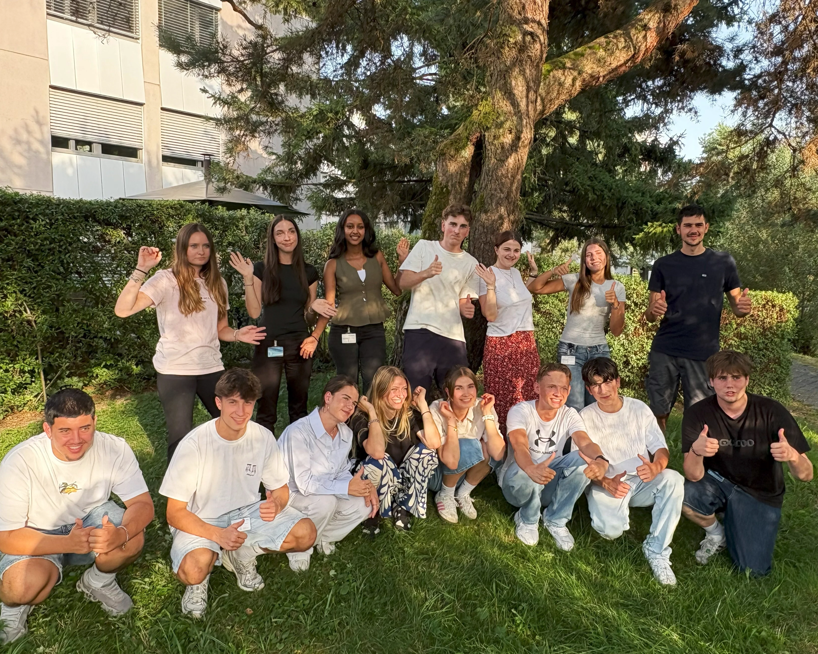 Die Bossard Auszubildenden stehen um das Bossard Schild am Platz Zug