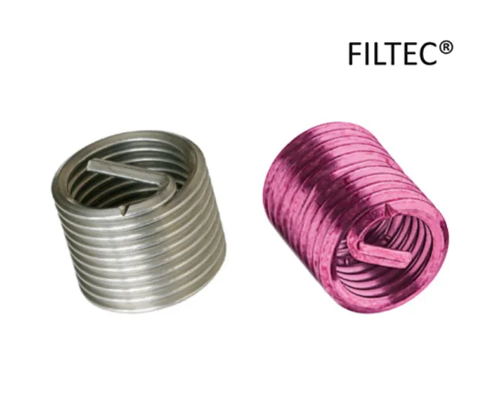 Zwei FILTEC Drahtgewindeeinsätze, einer silberfarben und einer pinkfarben, mit spiraliger Struktur auf weißem Hintergrund und FILTEC Logo.