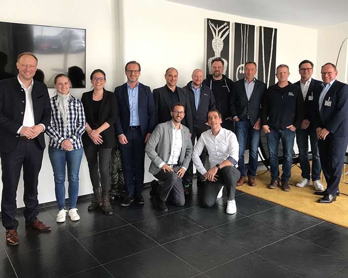 Gruppe von Fachleuten von Bossard und WEH posiert gemeinsam in einem geschäftlichen Umfeld