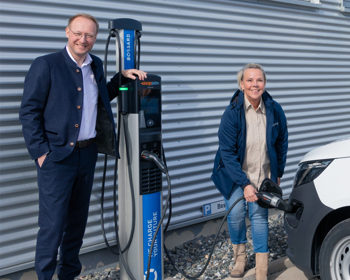 Geschäftsführer Daniel Stier und Mitarbeiterin an einer Bossard-Ladestation beim Laden eines Elektrofahrzeugs