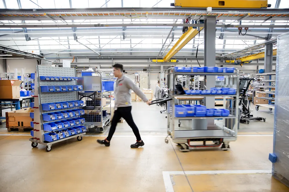 Milk Runner läuft durch moderne Lagereinrichtung, um Behälter in der Produktionshalle aufzufüllen