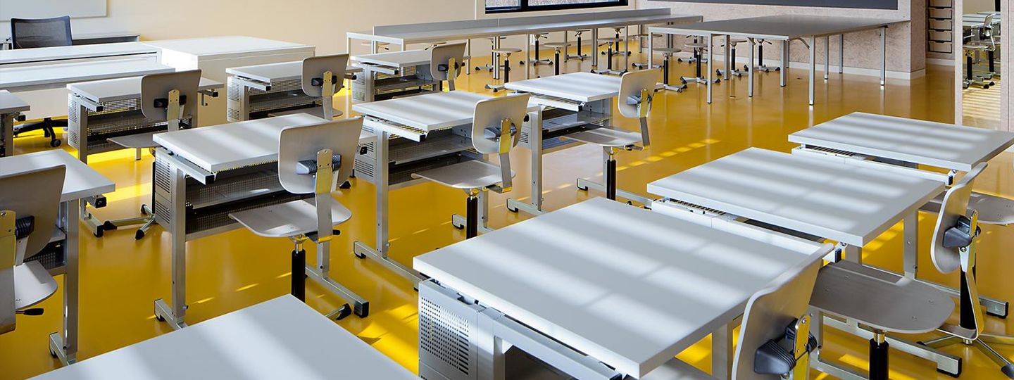 Ein gut eingerichtetes Klassenzimmer mit verschiedenen Tischen und Stühlen, das eine einladende Umgebung für Lernen und Zusammenarbeit schafft.