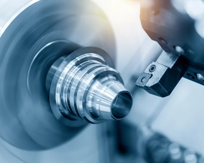 Nahaufnahme eines rotierenden Metallteils auf einer CNC-Drehmaschine, präzise bearbeitet für spezielle Anforderungen