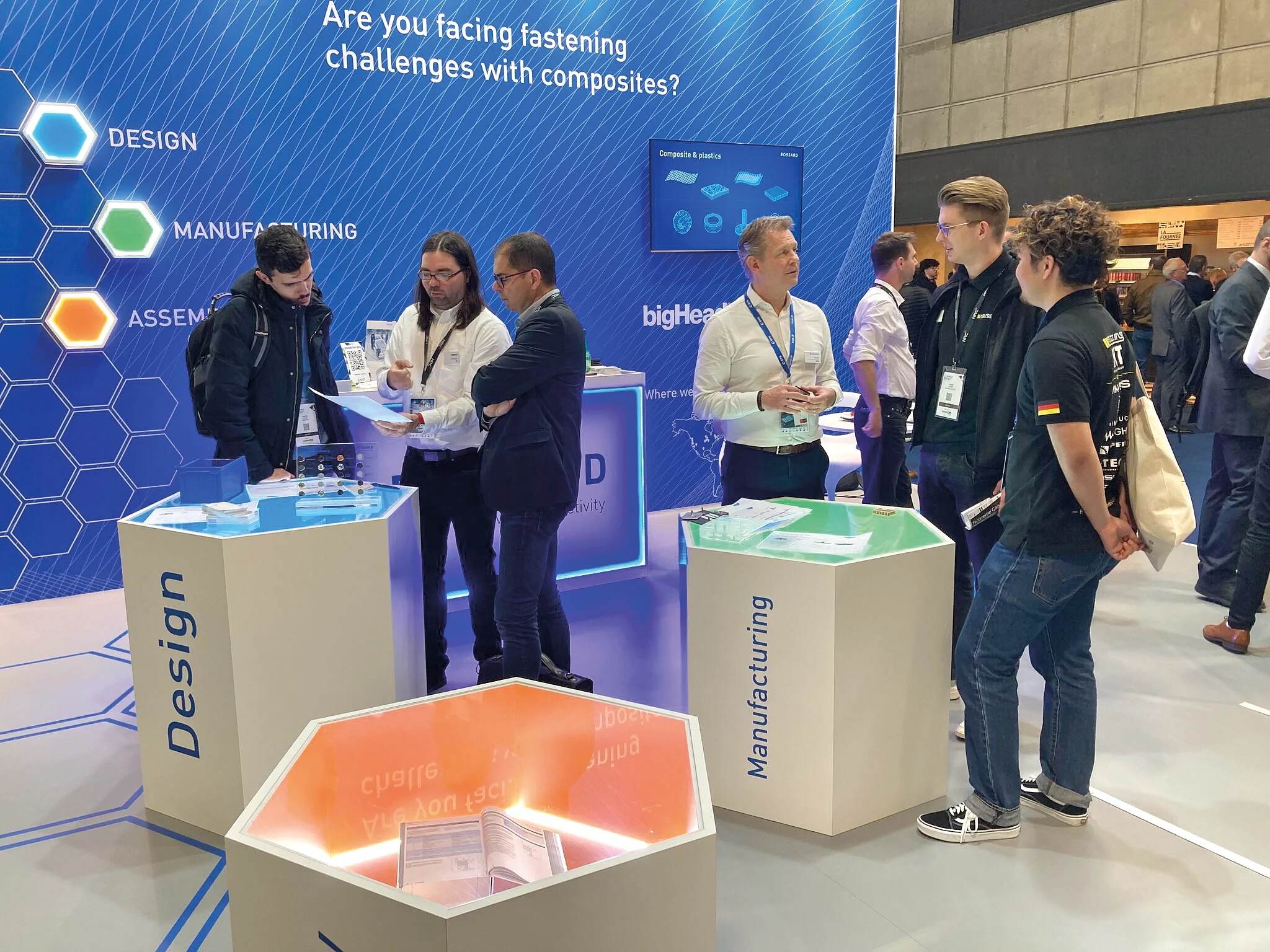 Bossard-Stand mit Personen, die Verbindungslösungen auf der JEC World in Paris, einer führenden Messe für Verbundwerkstoffe, diskutieren.
