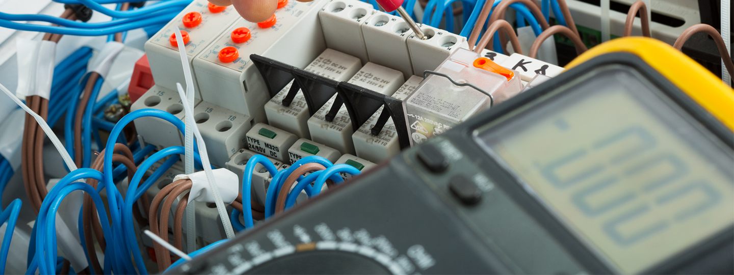 Nahaufnahme von elektrischen Verkabelungen und Geräten, die komplexe Verbindungen und wesentliche Komponenten für die Stromverteilung hervorheben.