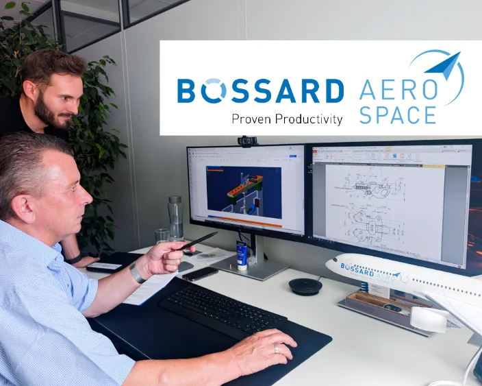 Zwei Personen diskutieren über eine luftfahrtbezogene Zeichnung auf dem Bildschirm