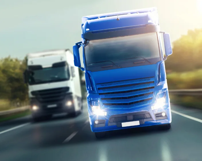 Blauer und weißer Lkw auf der Autobahn, zeigt Befestigungslösungen für Nutzfahrzeuge.