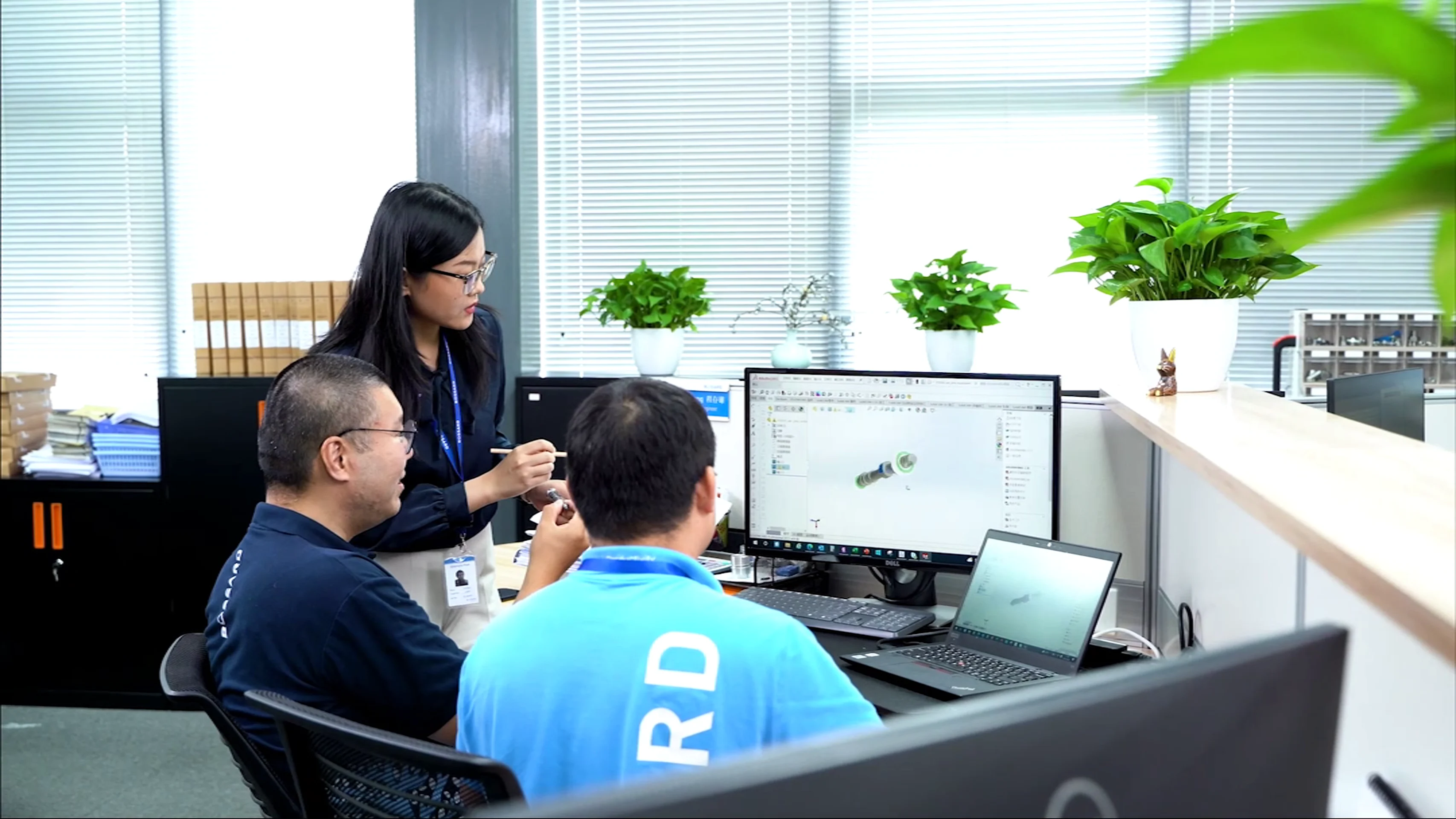 A diverse group of professionals collaborating on computers in a modern office environment.