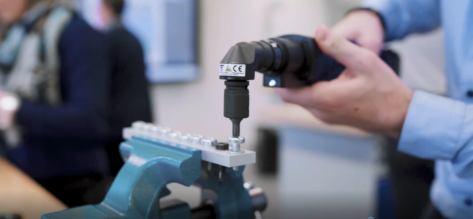 Eine Person verwendet eine Bohrmaschine, um ein Loch in ein Metallstück zu bohren.