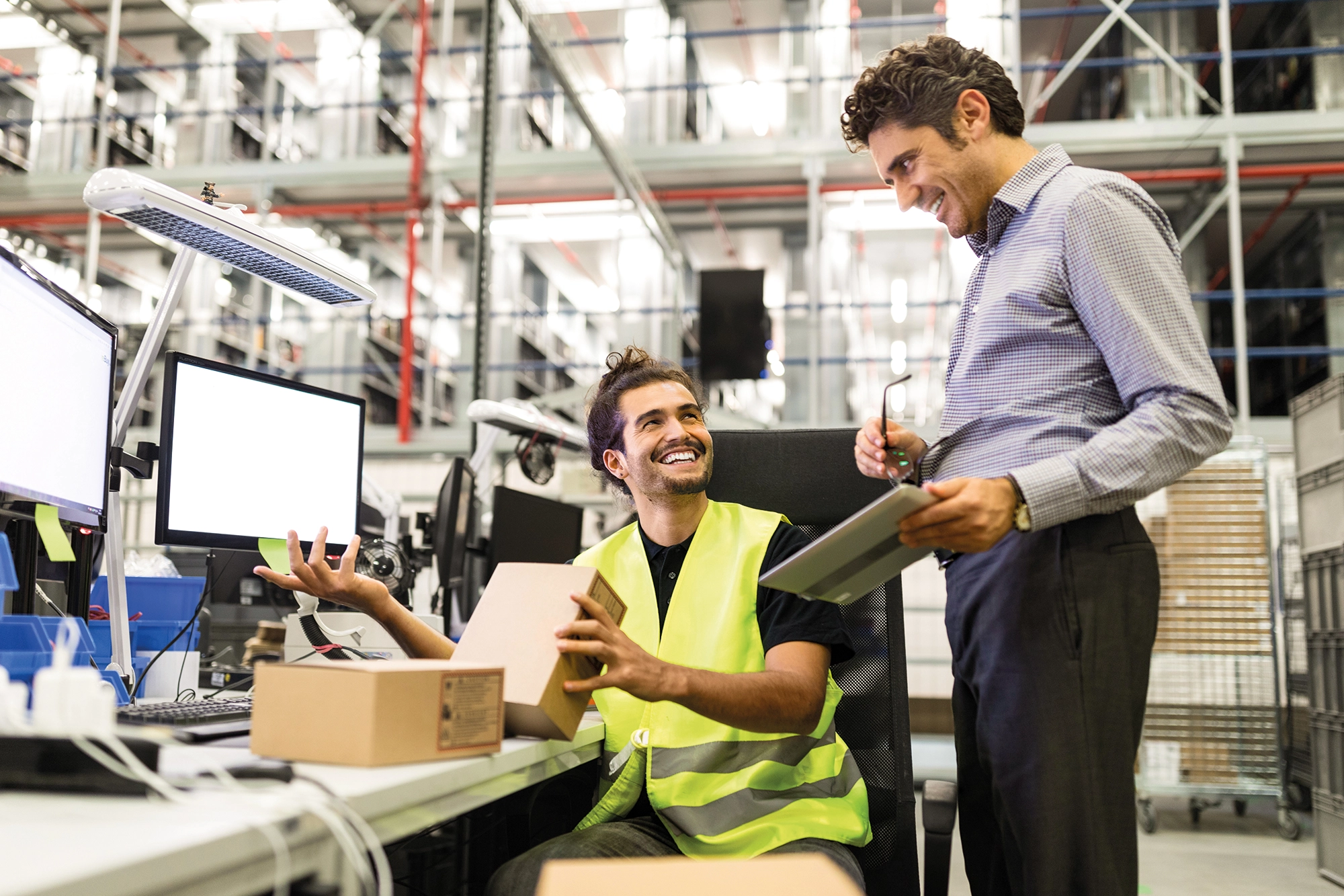 Warehouse manager and worker talking about order picking
