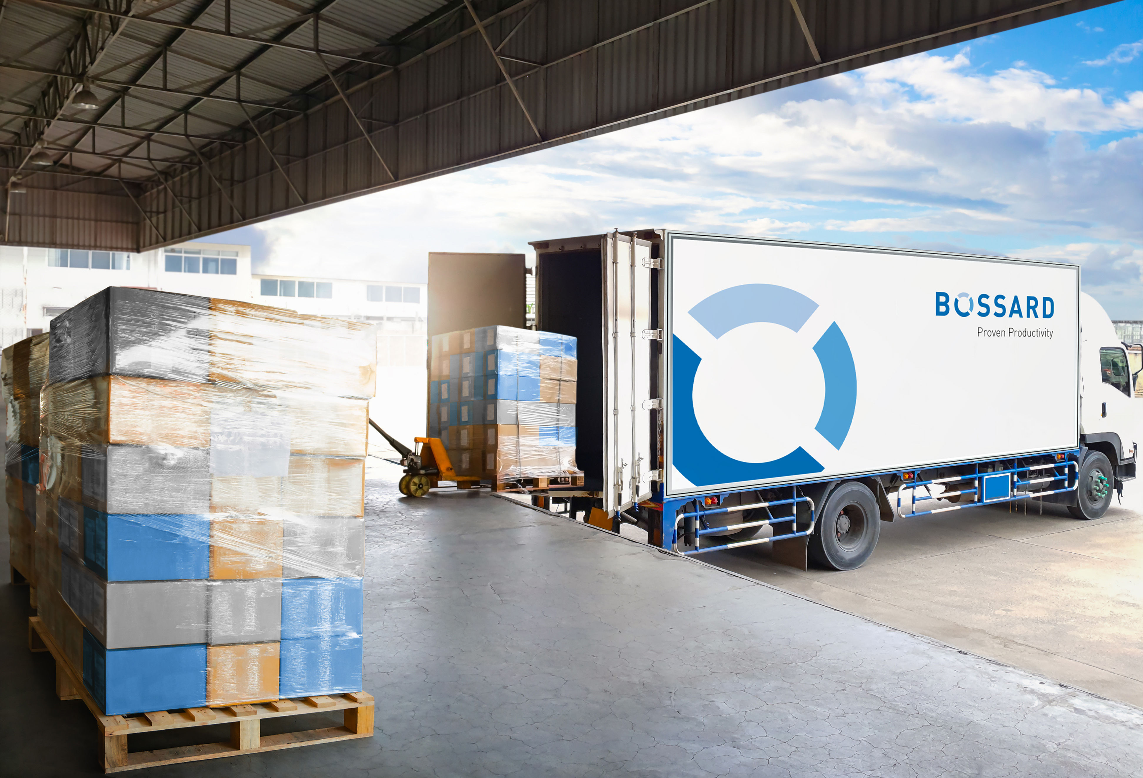 White Bossard delivery truck being loaded with wrapped pallets in warehouse loading bay.