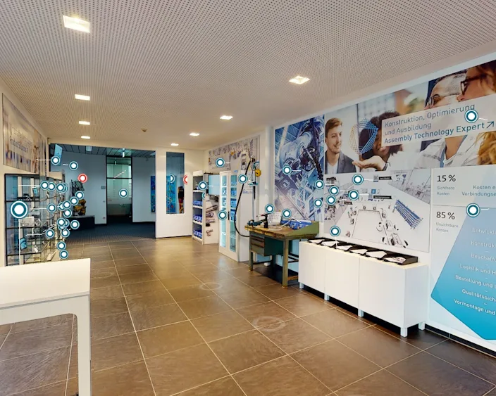 Moderner Ausstellungsraum mit interaktiven Markierungen für eine virtuelle Tour durch das Bossard Experience Center.