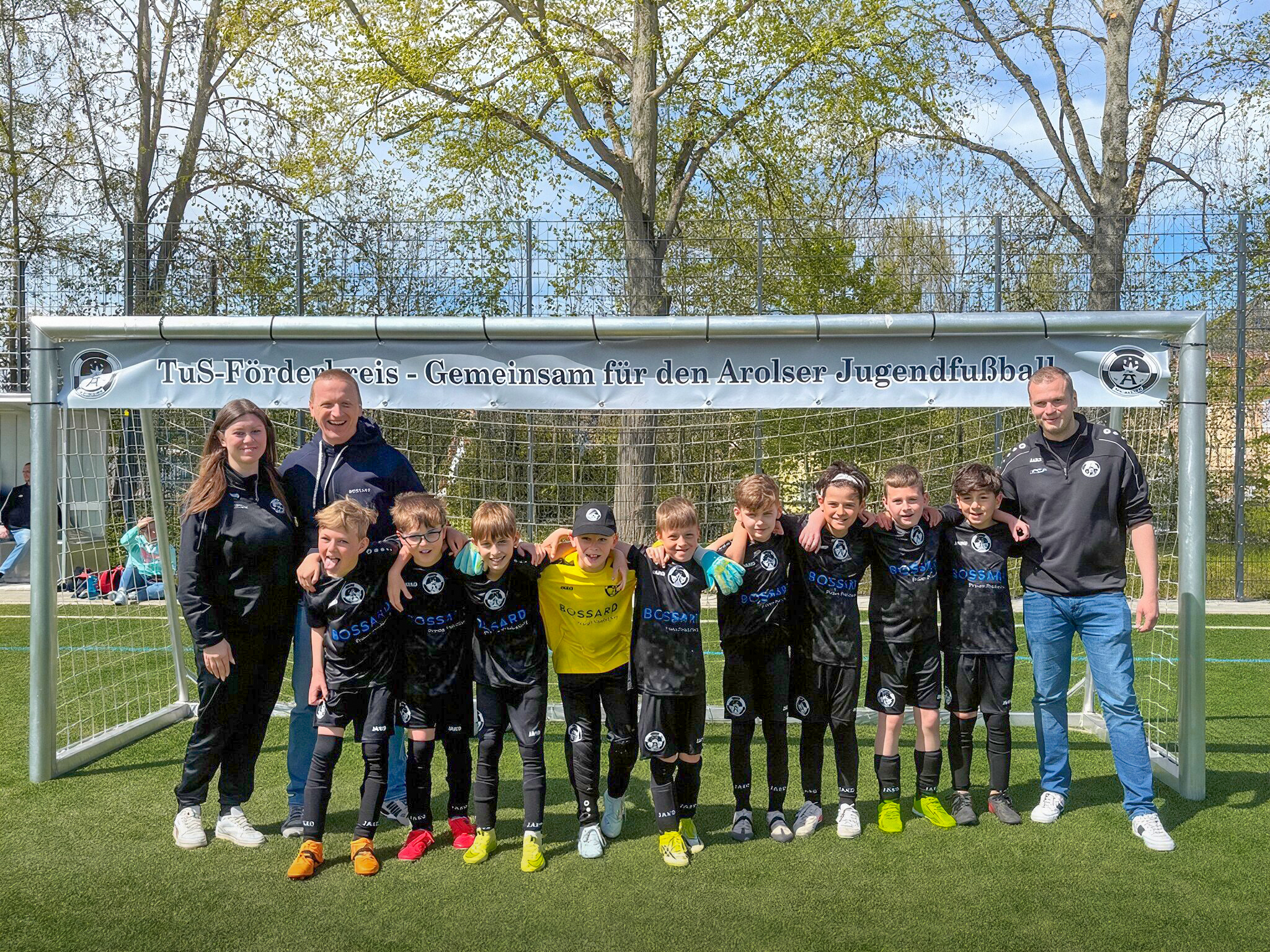 Gruppenfoto einer Jugendfußballmannschaft des TuS Bad Arolsen mit Betreuern vor einem Fußballtor.
