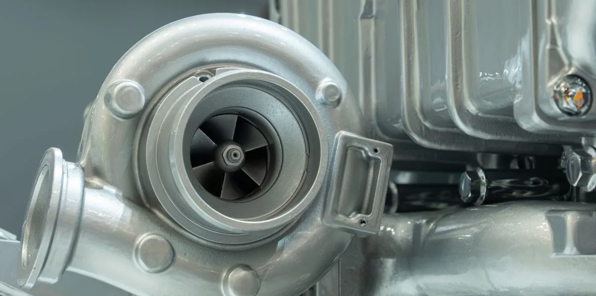 Vue rapprochée d'un moteur turbo avec un turbocompresseur proéminent, mettant en valeur des détails complexes et un design d'ingénierie.